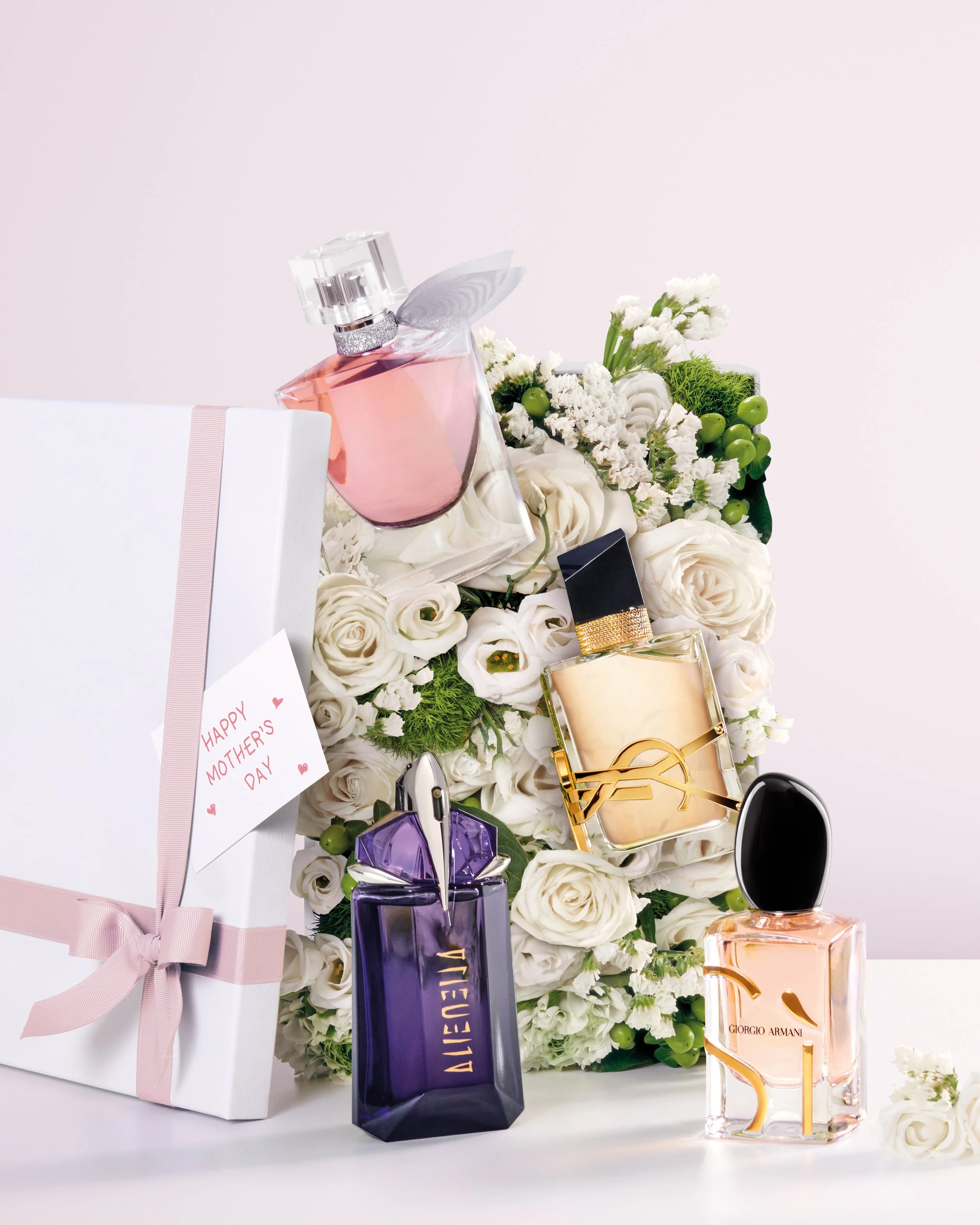L'Oréal Luxe Spring _ Un bouquet de fleurs blanches avec plusieurs flacons de parfum, un cadeau blanc avec un ruban rose, un message de fête des mères, et des fleurs blanches