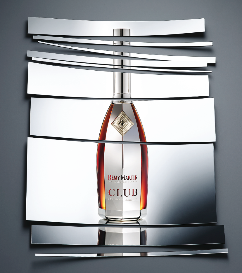 Remy Martin Club Campaign _ Publicité pour la bouteille de champagne Rémy Martin Club, avec un effet visuel décomposant la bouteille en plusieurs segments, sur un fond gris.
