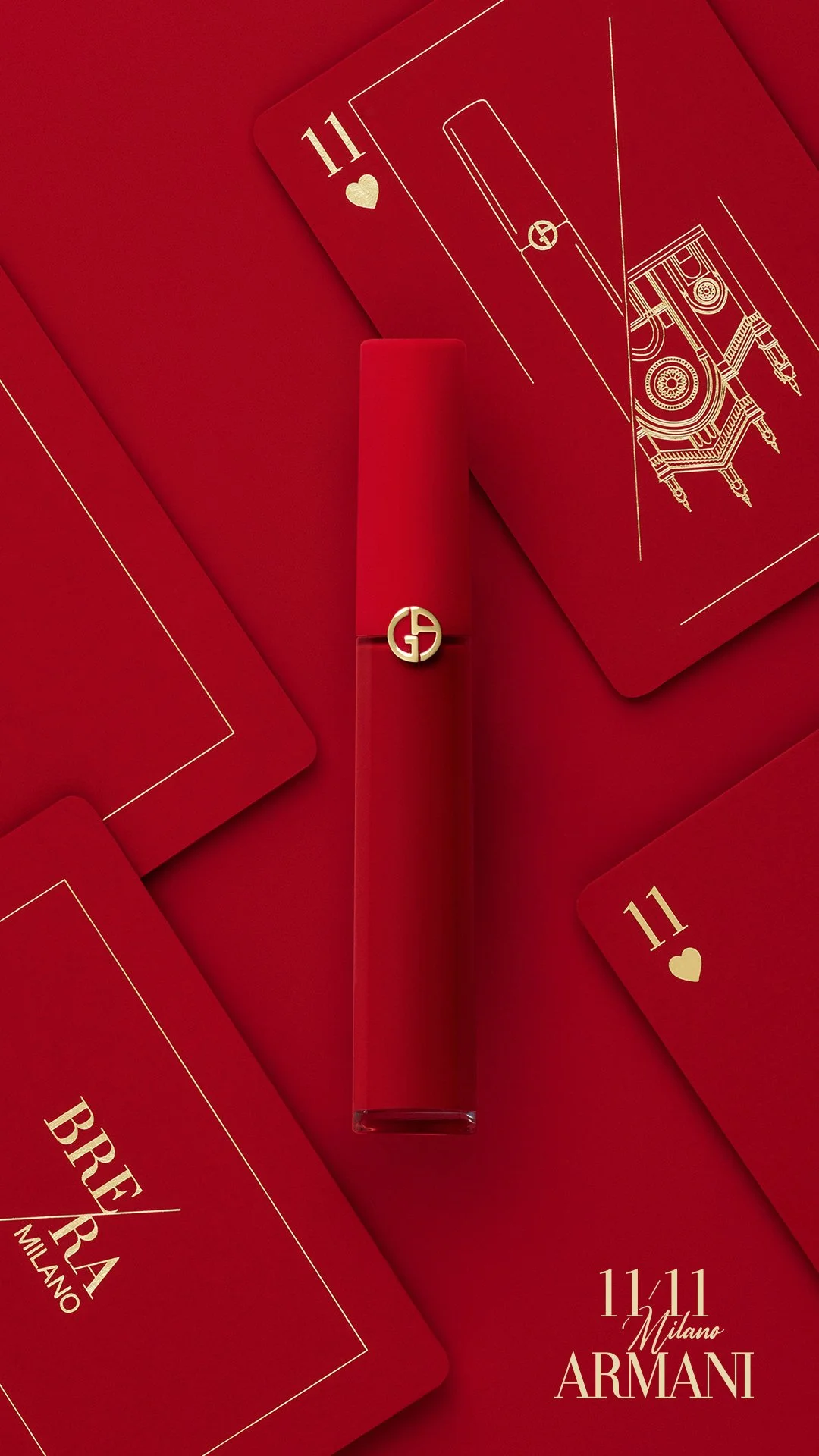 ARMANI Double Eleven 11.11 _ Une bouteille de parfum Armani Rouge à côté de plusieurs cartes à jouer de couleur rouge, notamment deux cartes 11 de cœur, sur un fond rouge.