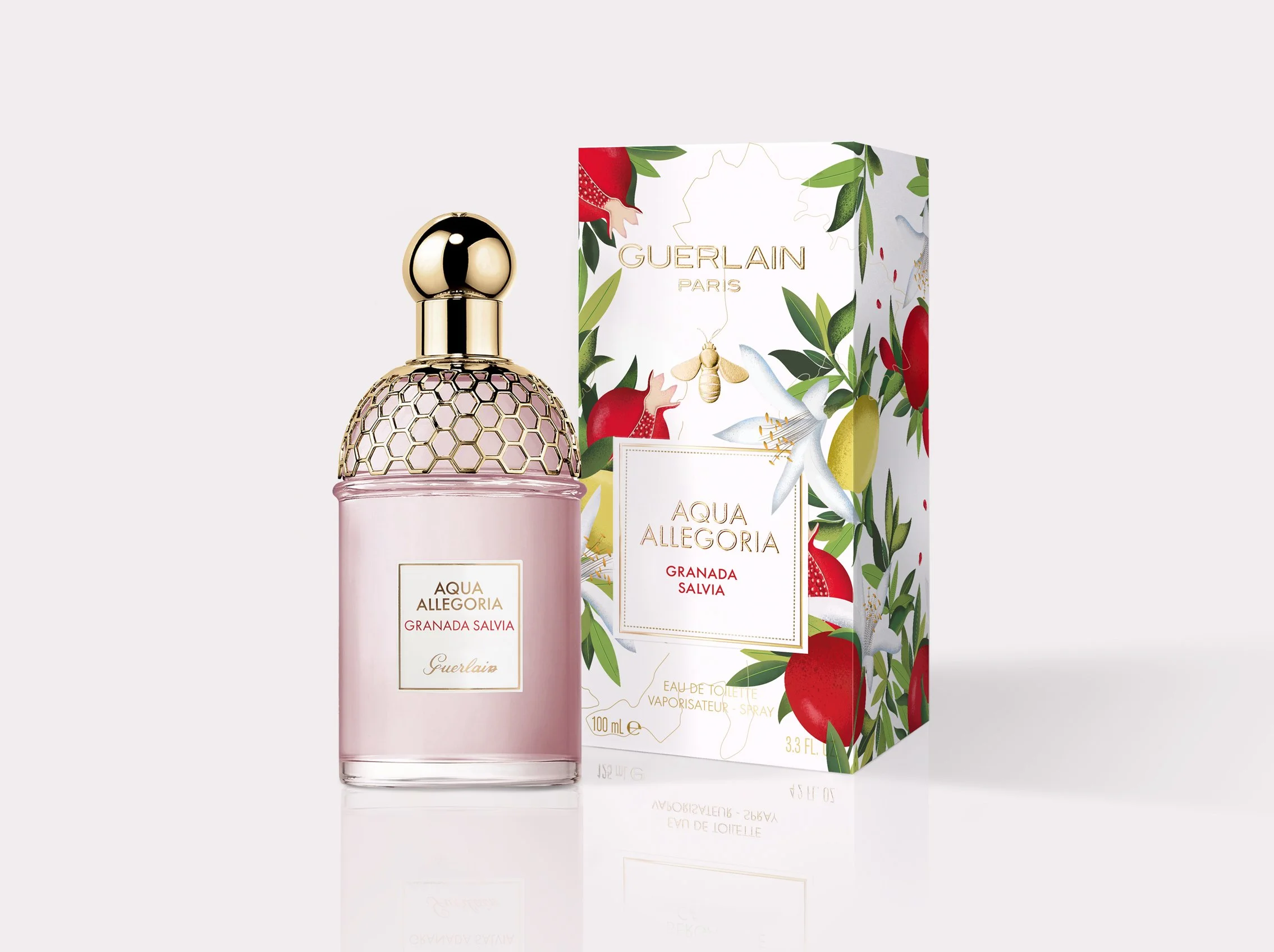 Guerlain Aqua Allegoria _ Un flacon de parfum rose avec un couvercle doré en forme de boule, et une boîte à côté avec un design floral représentant des grenades, des fleurs blanches et des feuilles, de la marque Guerlain.
