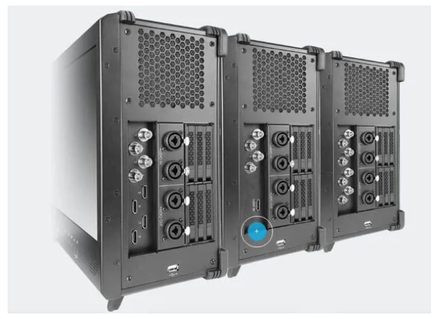 Three professional audio power amplifiers mounted side by side, with visible cooling vents, connection ports, and adjustable controls.