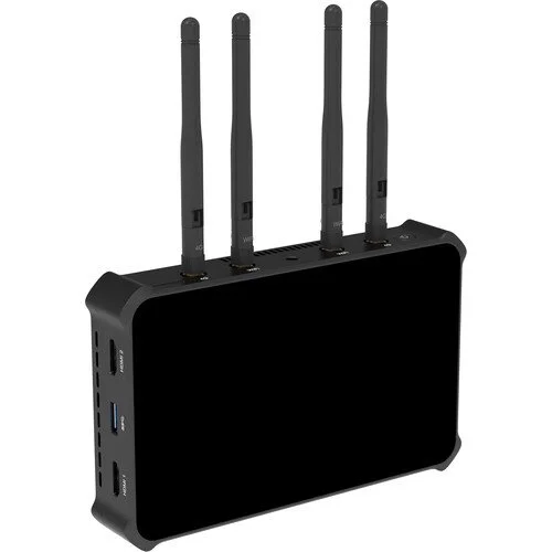 Black networking device with four antennas and multiple ports on the side.