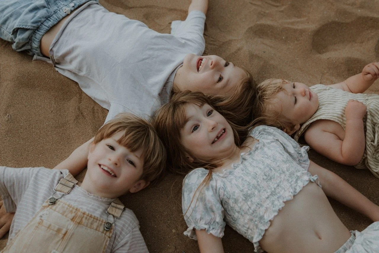 Family lying together outdoors during a relaxed family photography session in Hertfordshire.