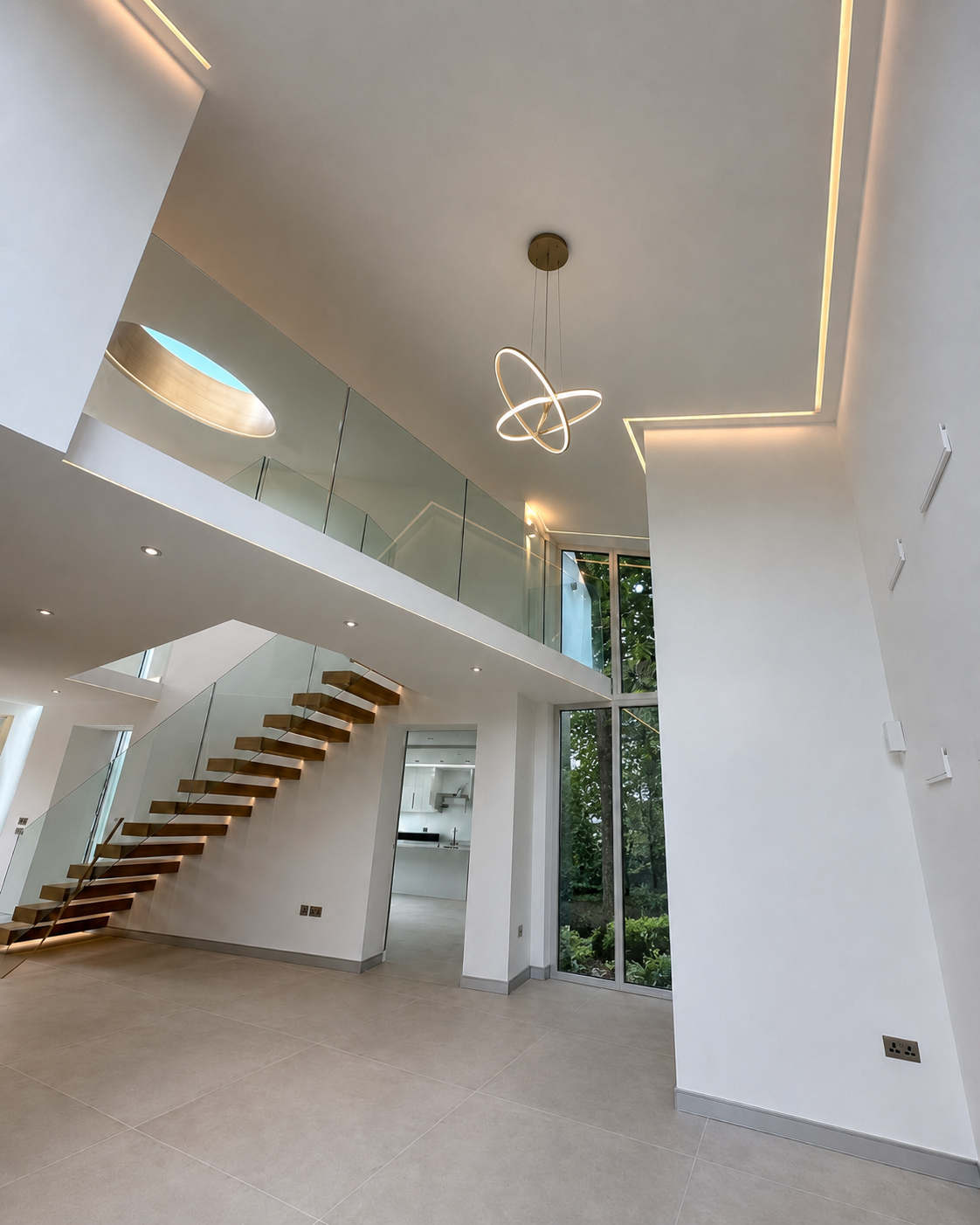 Modern interior of a house featuring a staircase with wooden steps, large floor-to-ceiling windows, a sleek hanging light fixture, a balcony with glass railing, and minimalist design elements.