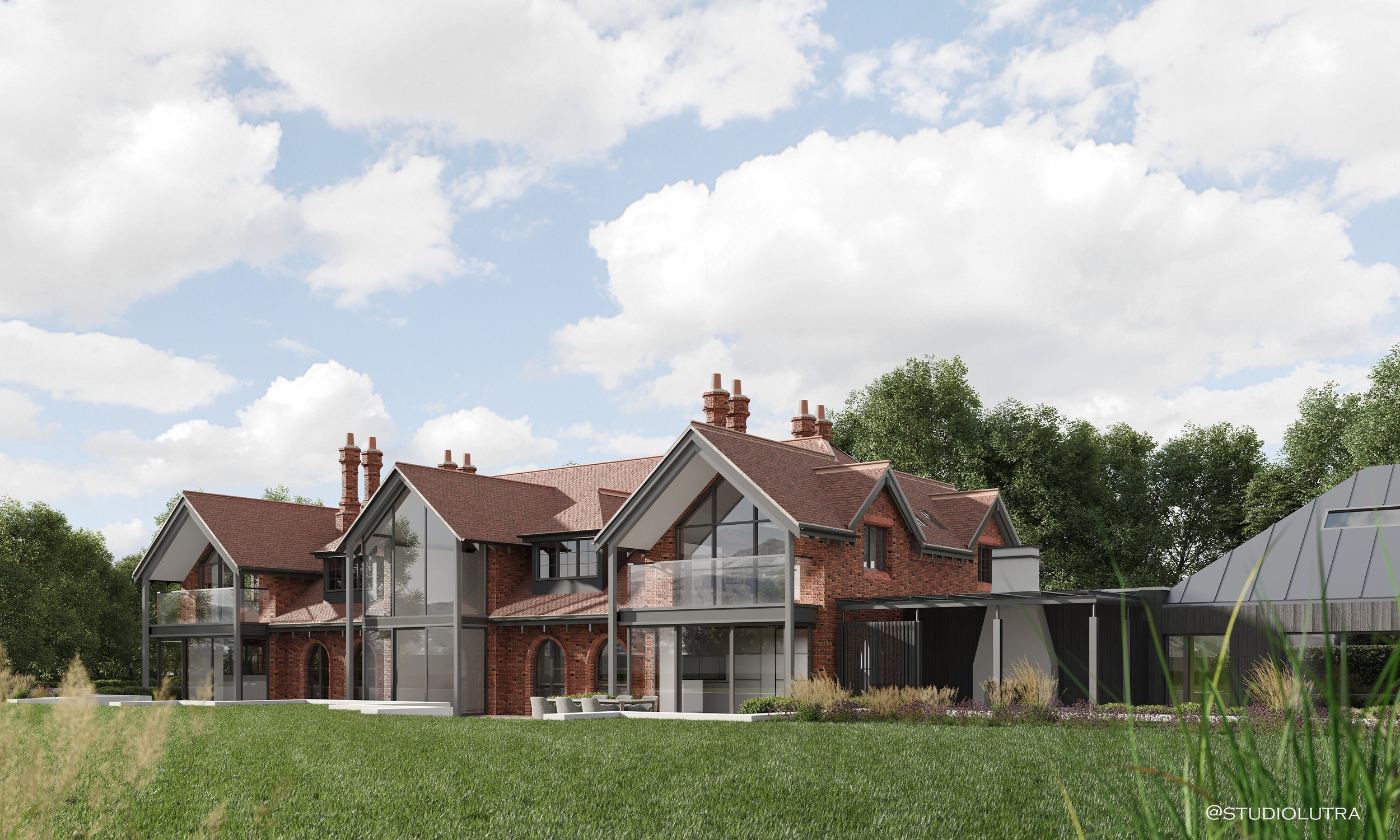 A modern house with brick and glass exterior, multiple gabled roofs, and surrounded by green lawn and trees.