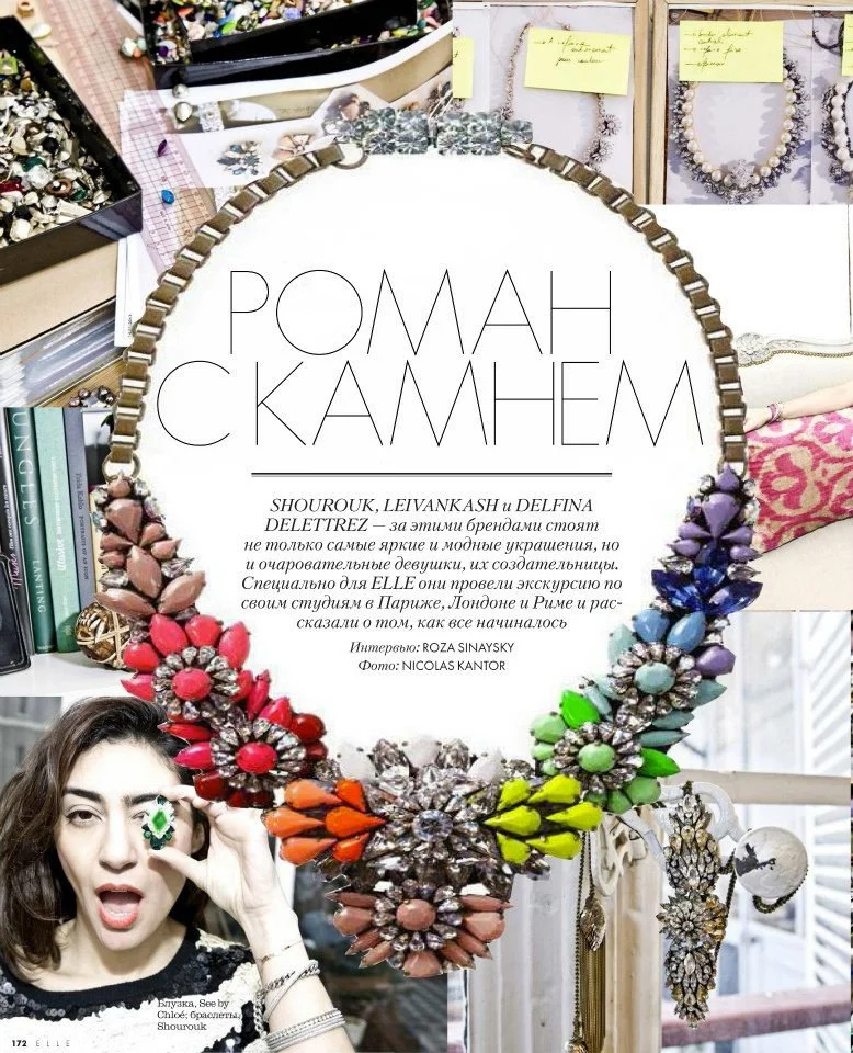 Colorful statement necklace with large pink, coral, orange, yellow, green, blue, purple, and clear gemstones, displayed on a magazine page. The page features a woman with dark hair wearing rings, jewelry, and a black top, and has Korean and Russian t