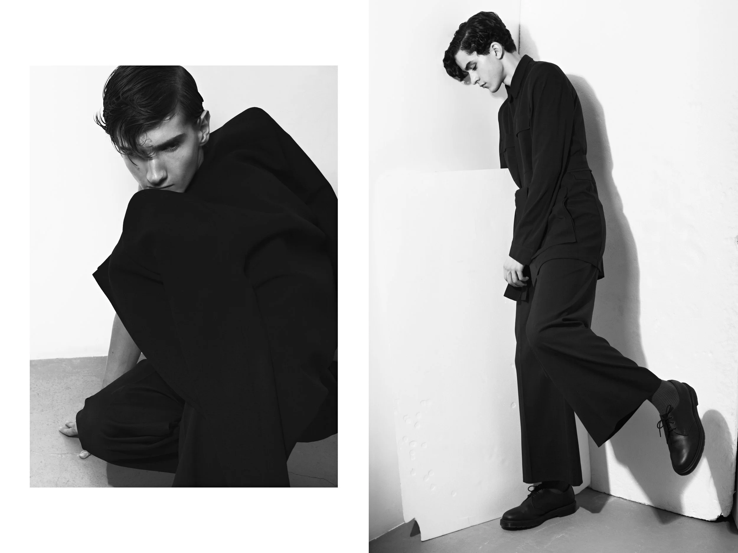 Two black and white fashion photographs of a young man with dark hair wearing dark clothing, posing against a white background. The left image shows him crouched with his arms around his legs, looking intently at the camera. The right image shows him