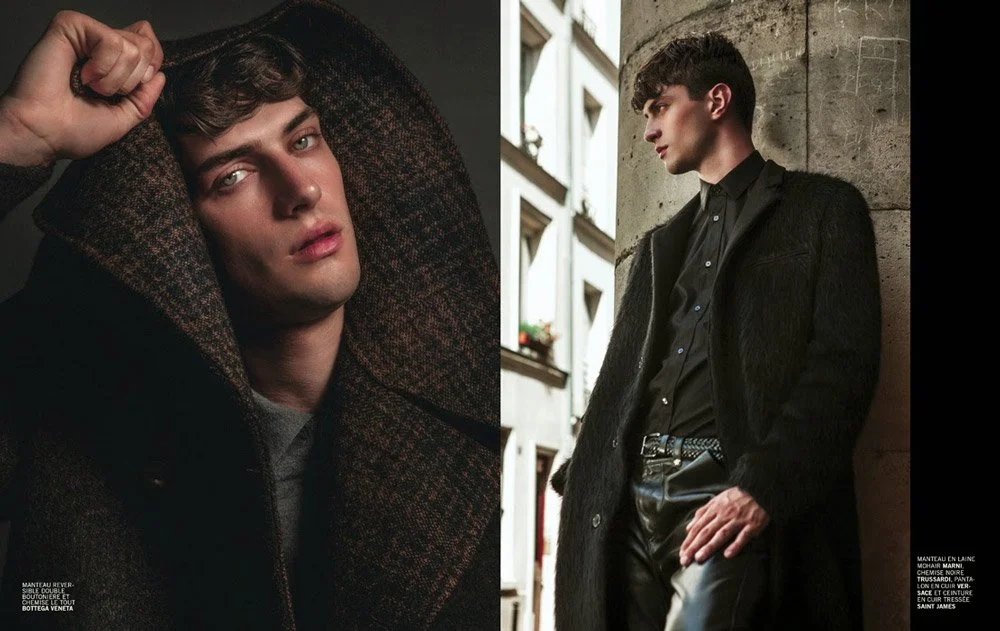 Two young men with dark hair and light skin posing in stylish black clothing in urban settings, one lying down indoors and the other leaning against a wall outdoors.