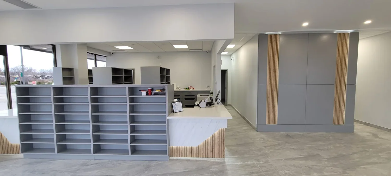 Interior of a modern reception area with a reception desk, open shelves, and wood accents.