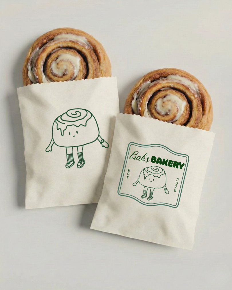 Two cinnamon rolls in bakery paper bags with a cute cinnamon roll character illustration, one on each bag, and the bag on the right has a label reading "Babe's Bakery" with the same character, established 2026.