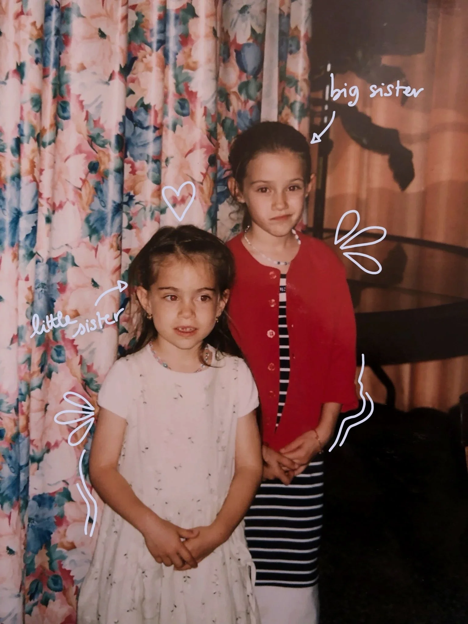 Two young girls standing in front of floral curtains, with handwritten annotations describing one as a 'little sister' and the other as 'big sister.'