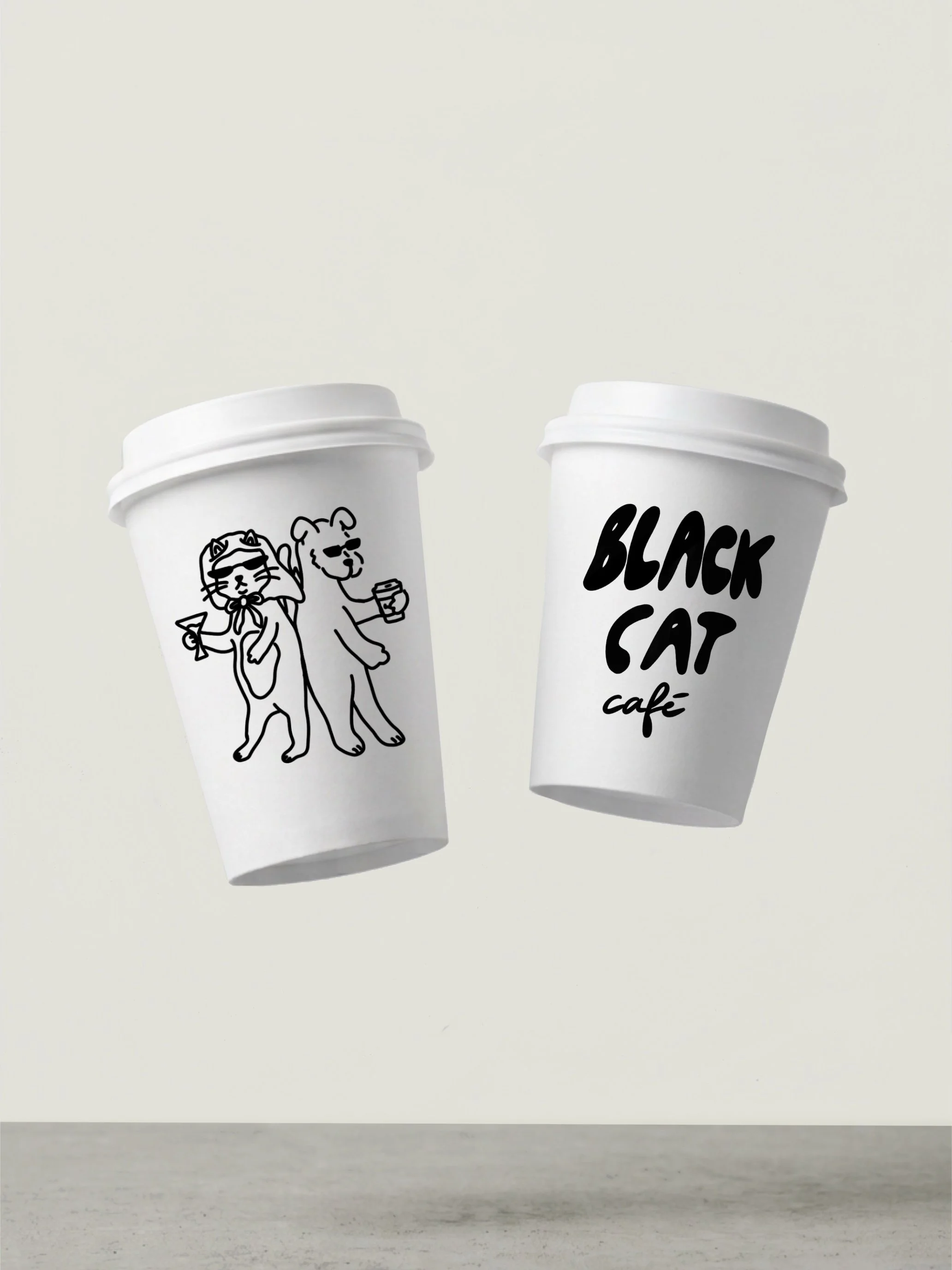 Two white takeout coffee cups, one with a black line drawing of a cat and a dog wearing sunglasses and holding a coffee cup, the other with the text 'Black Cat Cafe,' on a light background.