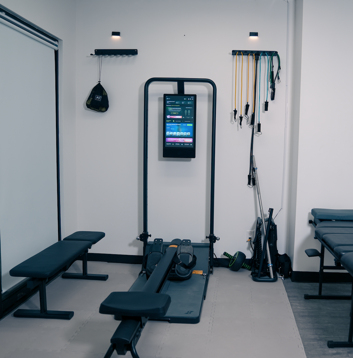 A young man with a backpack stretching his leg on a skateboard in an open outdoor space, black and white photo.
