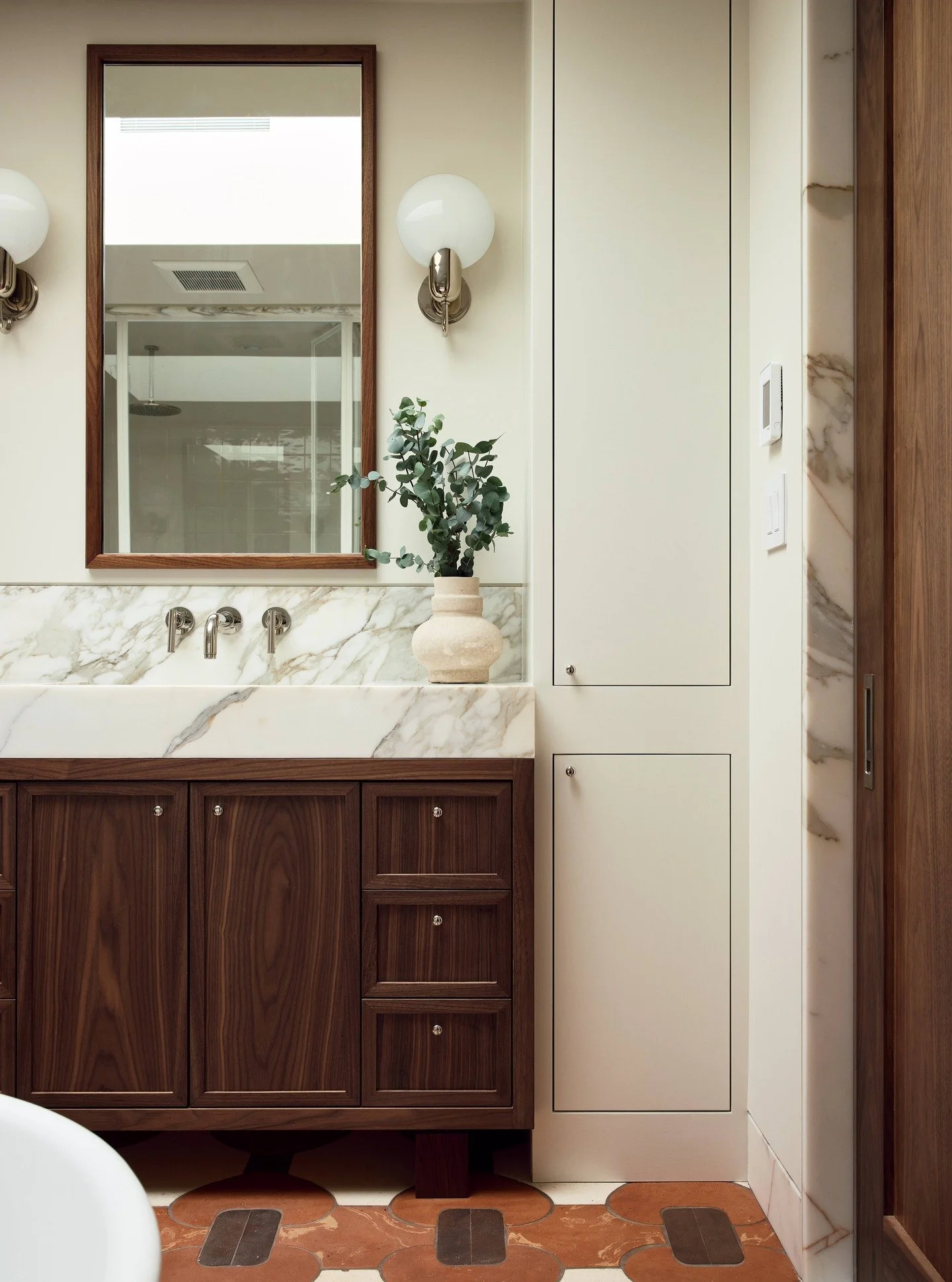 A bathroom built with precision from the inside out. Natural light from the skylight, bookmatched stone transitions, custom millwork, and a fully integrated wet room framed in slim-profile metal. 
Every detail like waterproofing, concealed fixtures, 