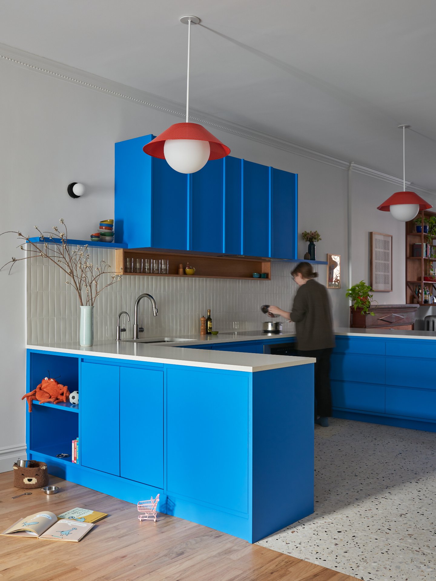 This kitchen mixes strong color with careful craftsmanship.
Custom blue millwork, a red tile niche, and warm oak cabinetry required precise alignment and coordination across finishes.
Vertical tile, terrazzo floors, and clean edges keep the space bal