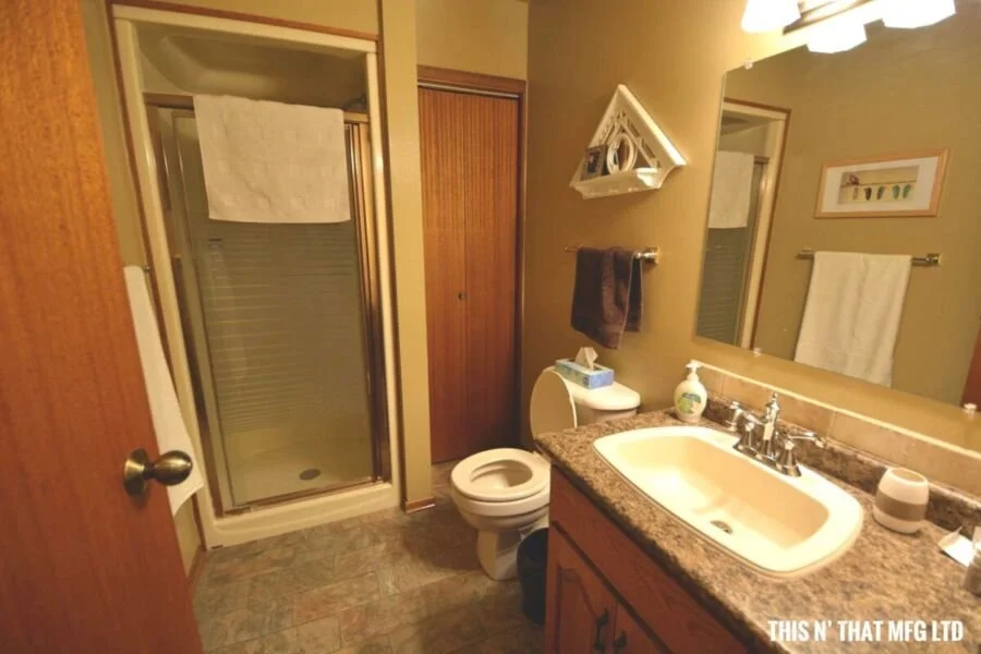 Bathroom with a glass shower, toilet, vanity with sink, mirror, and towels