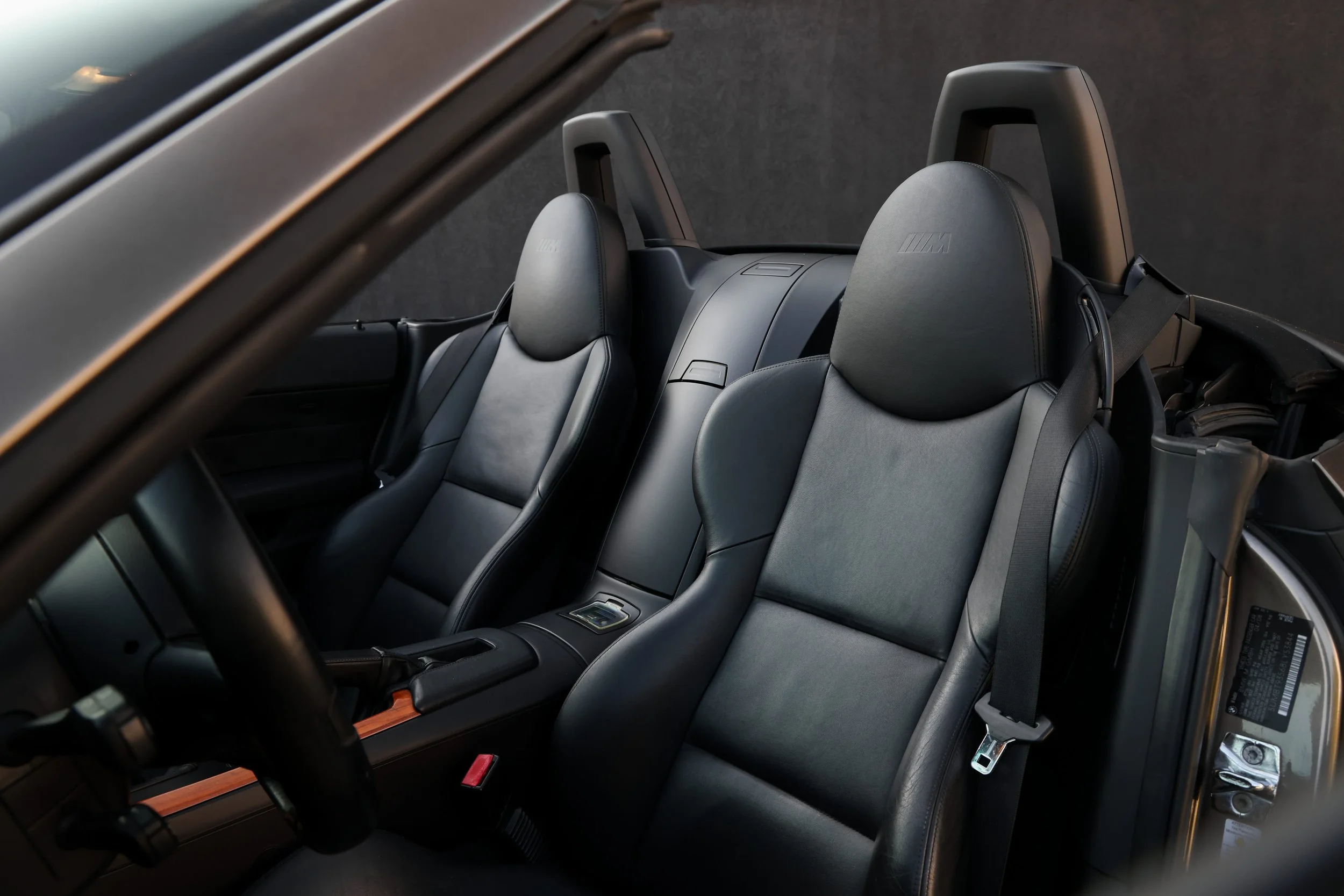Interior view of a modern car with black leather seats, center console, and a dashboard, with the driver's seat visible in the foreground.