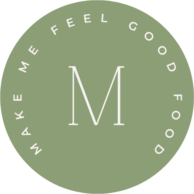 Green circular logo with white text that says "Make Me Feel Good Food" around the edge and a large letter "M" in the center.