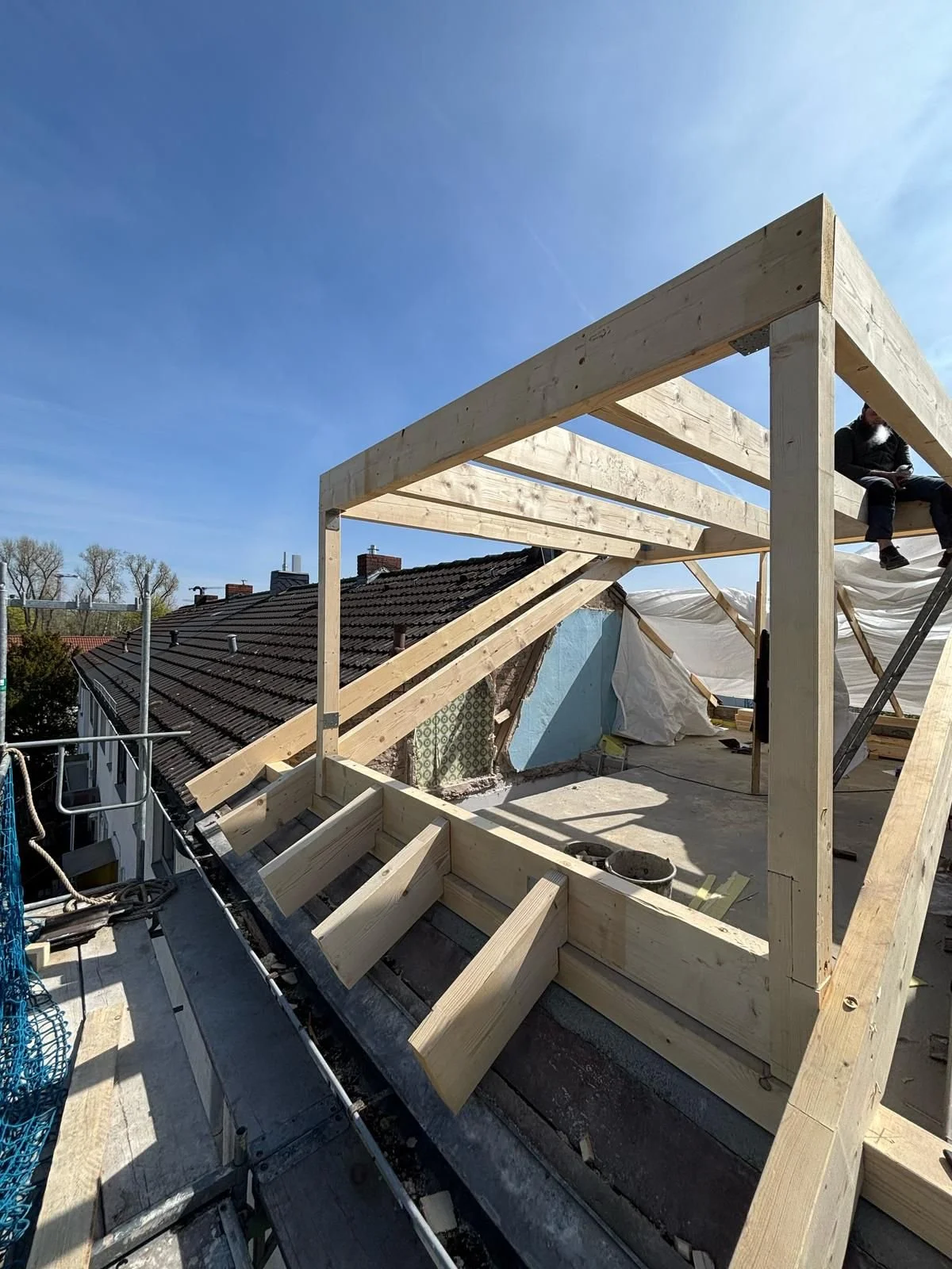 Bau eines Holzrahmens auf einem Dach an einem sonnigen Tag.