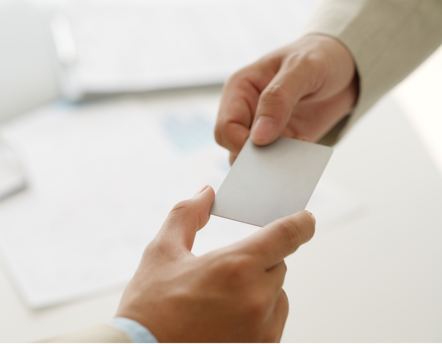 2 hands passing a small business card-sized paper.