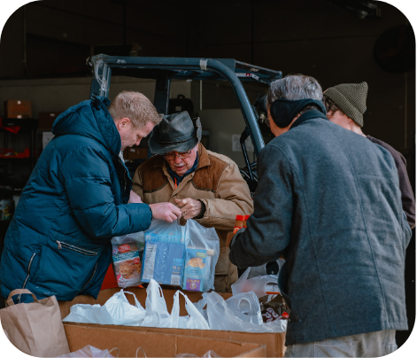 Four volunteers placing donations into a box to be weighed.
