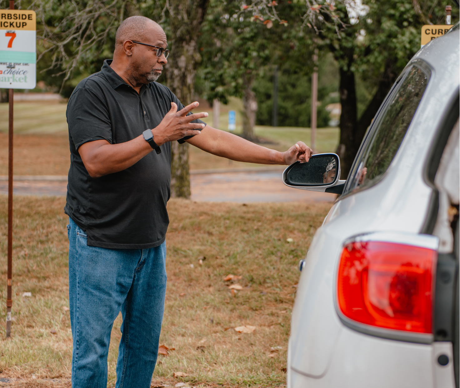 Grady Smith, a client support coach at WARM, is talking to a client at curbside pickup.