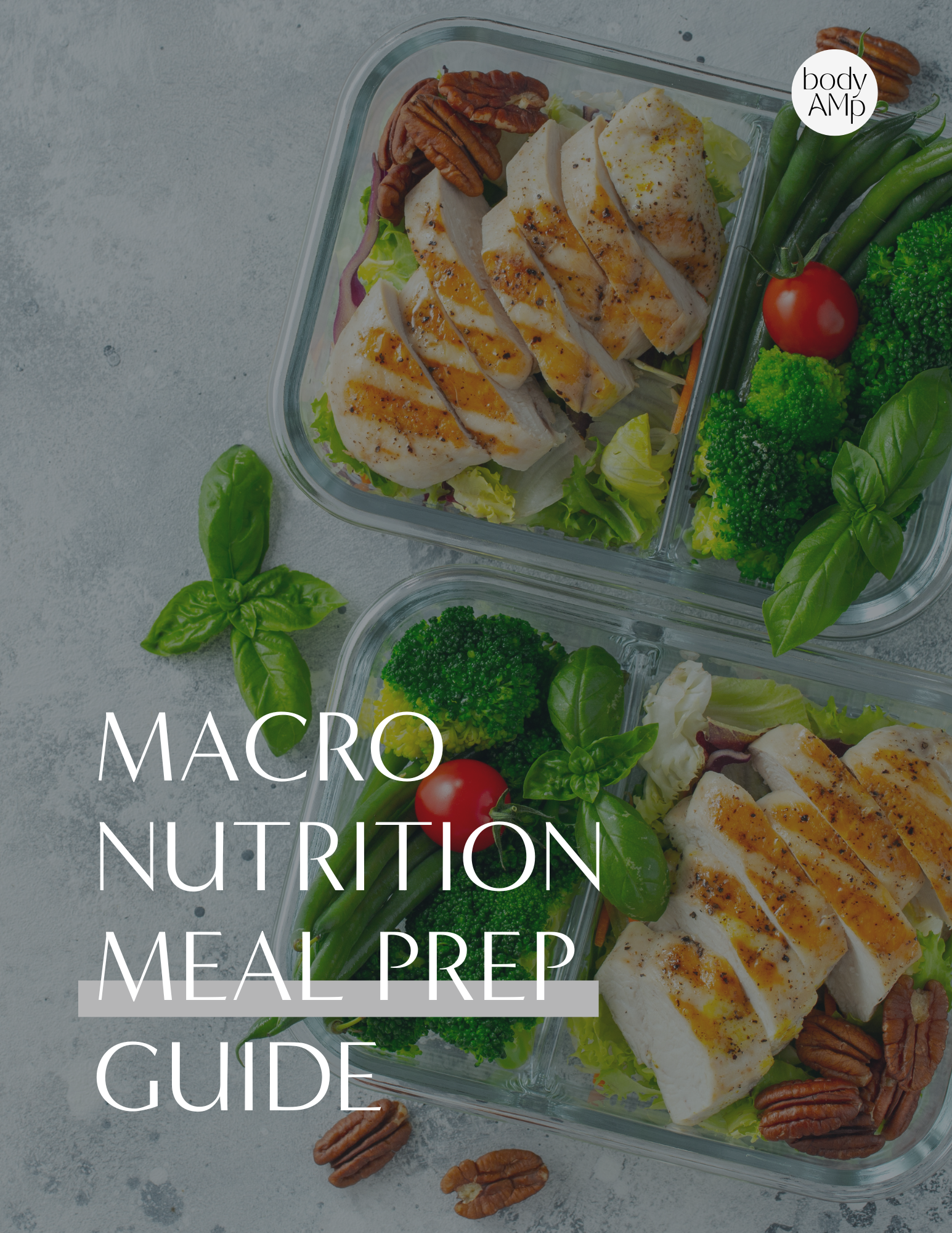 Two glass meal prep containers filled with grilled chicken, cherry tomatoes, broccoli, green beans, lettuce, and fresh basil leaves on a gray surface.