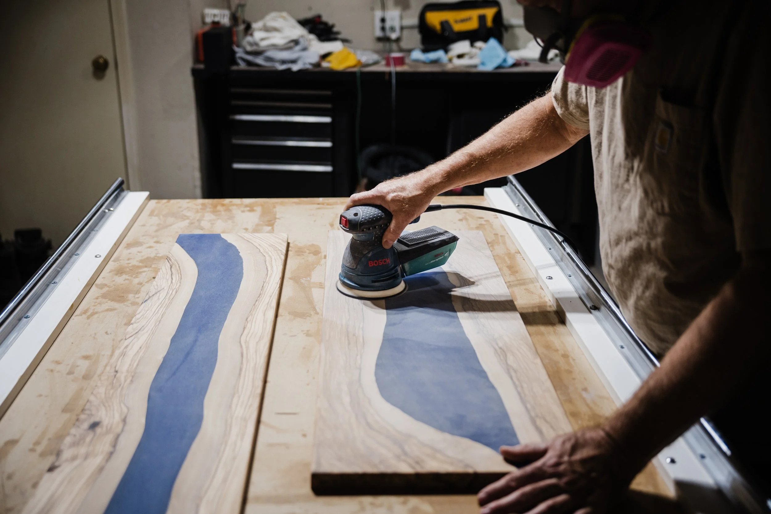 A craftsman in Tulsa, Ok working on a custom resin river black walnut table