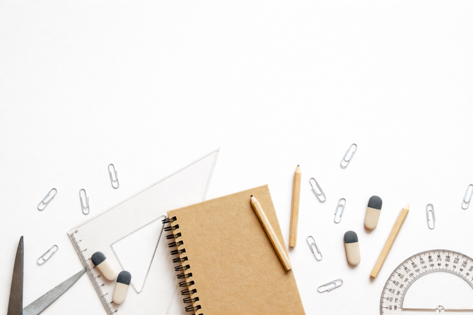 School supplies including a notebook, pencils, erasers, paper clips, scissors, a ruler, a protractor, and a triangular scale, arranged on a white background.