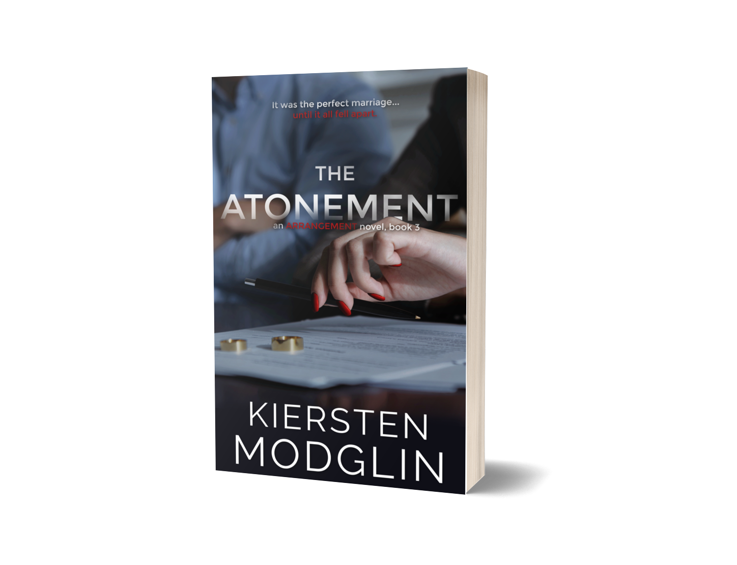 Book titled "The Atonement" by Kiersten Modglin. The cover features a woman's hand with red nails holding a pen above a document, with gold rings and blurred people in the background.