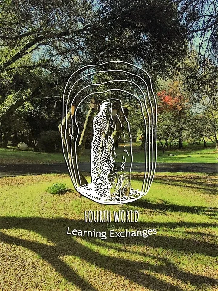 Metal art of a jaguar with the words "FOURTH WORLD Learning Exchanges" mounted on a grassy area in a park with trees in the background.