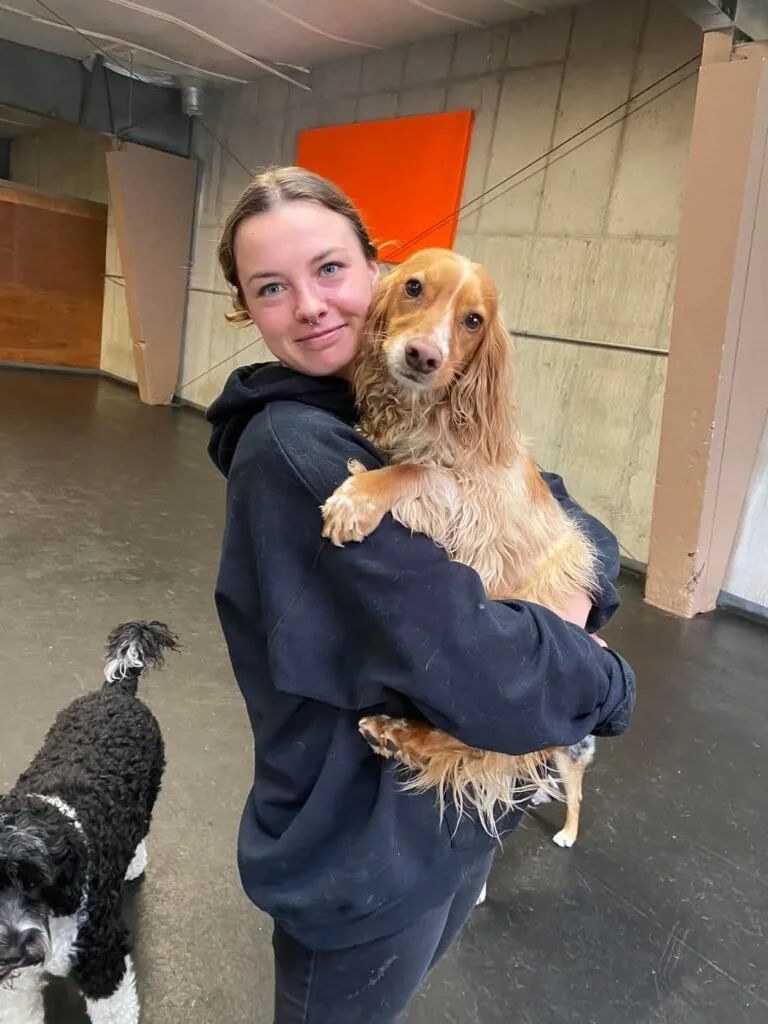 Bekah holding a tan-colored Cocker Spaniel 