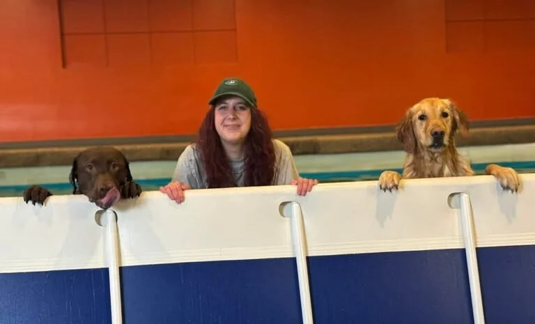 Haley sitting in a pool with two dogs