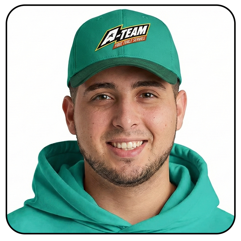 Young man wearing a teal hoodie and matching teal cap with a logo that says 'A-Team Fruit Table Service' and a star emblem.