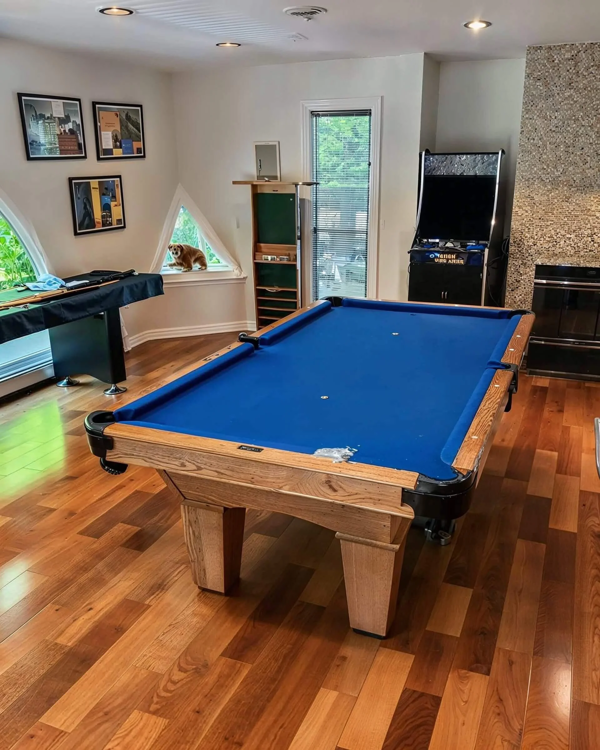 Pool table with a blue felt surface in a game room.