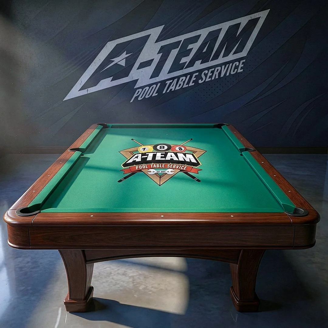 Custom pool table with A-TEAM Pool Table Service logo on green felt, set in a room with a dark wall featuring a large A-TEAM Pool Table Service sign or mural.