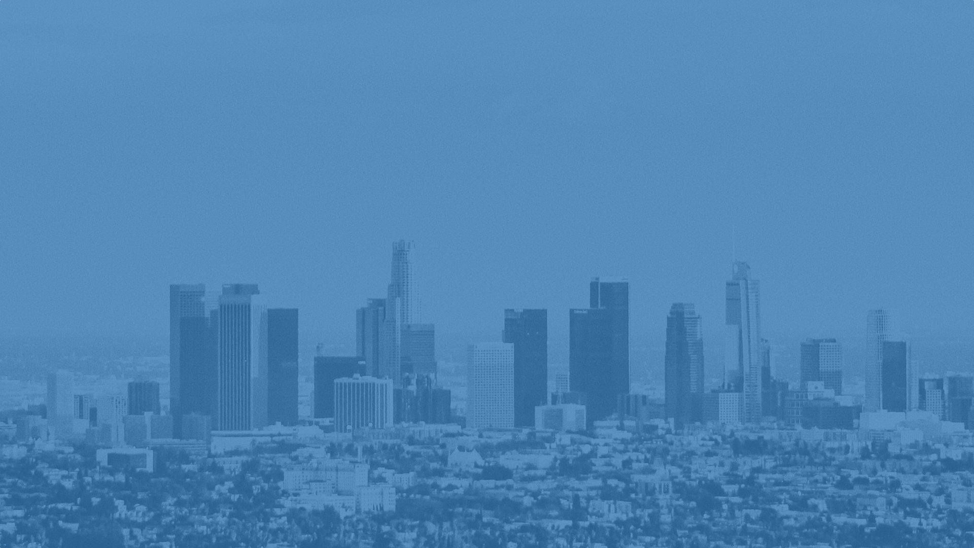 Blue-tinted photo of Los Angeles skyline with tall skyscrapers and cityscape