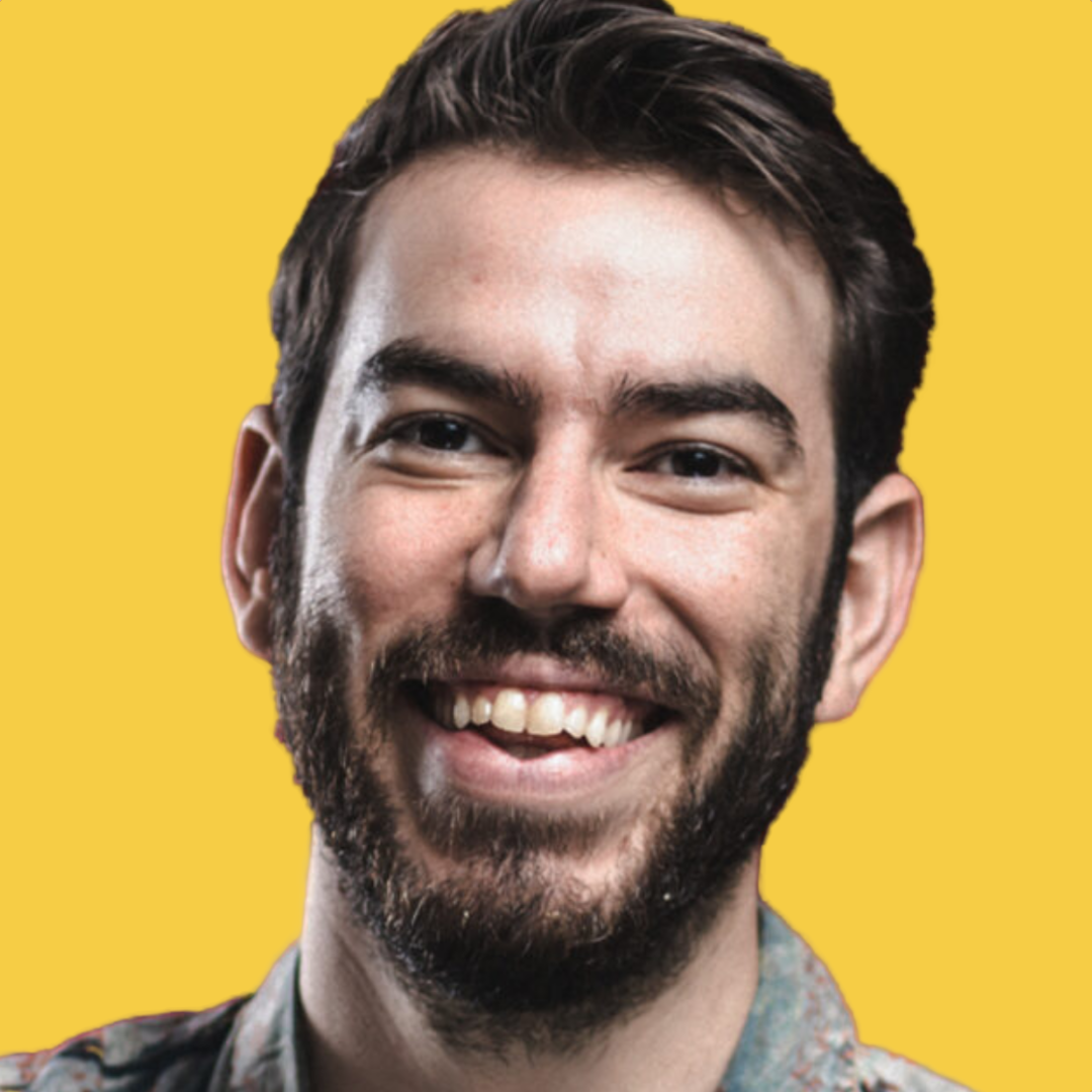 Close-up of a smiling young man with a beard against a yellow background.