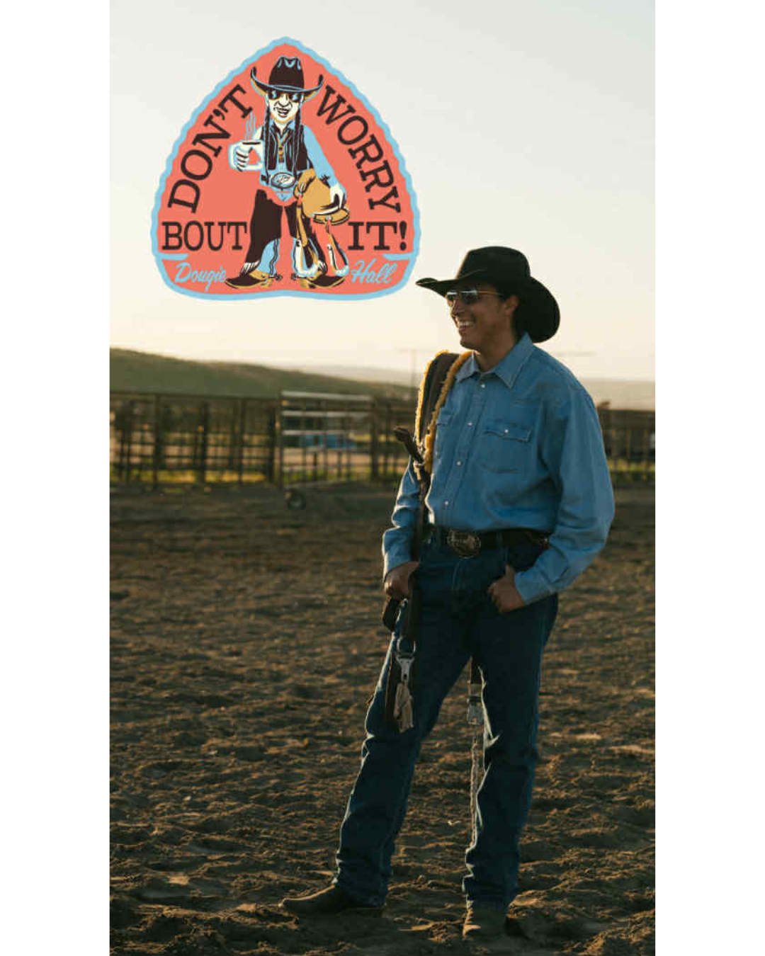 A person dressed as a cowboy, wearing a hat, sunglasses, a blue button-up shirt, and jeans, standing on a dirt horse riding arena with a fence in the background during sunset. There is a colorful sign with a cartoon cowboy figure and the words 'Don't Worry About It!'' in the sky above.