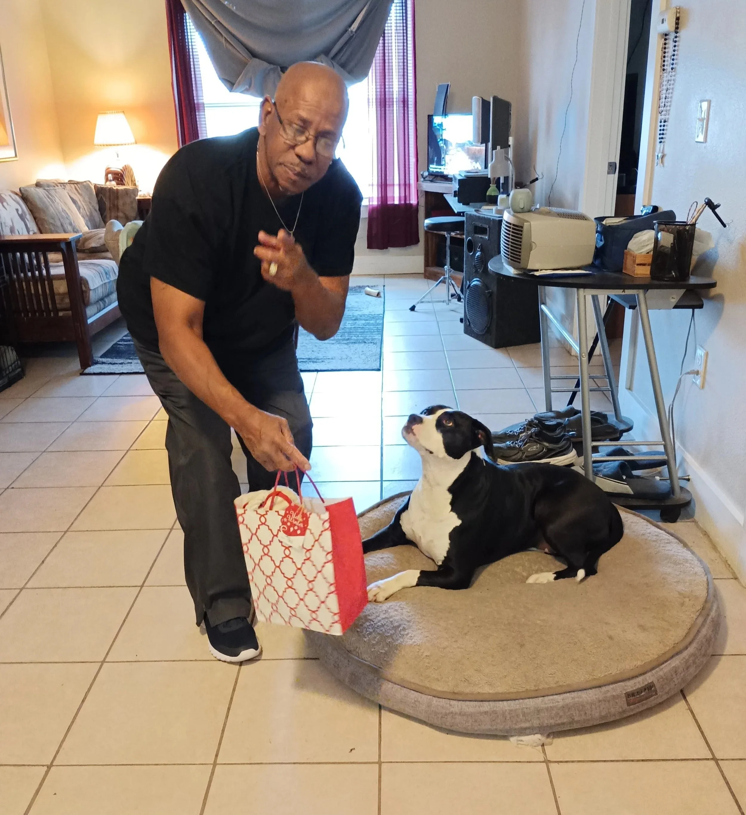 Man holding gift bag poses with dog