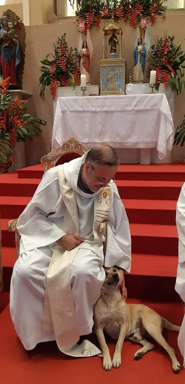 Priest wth dog at Mass
