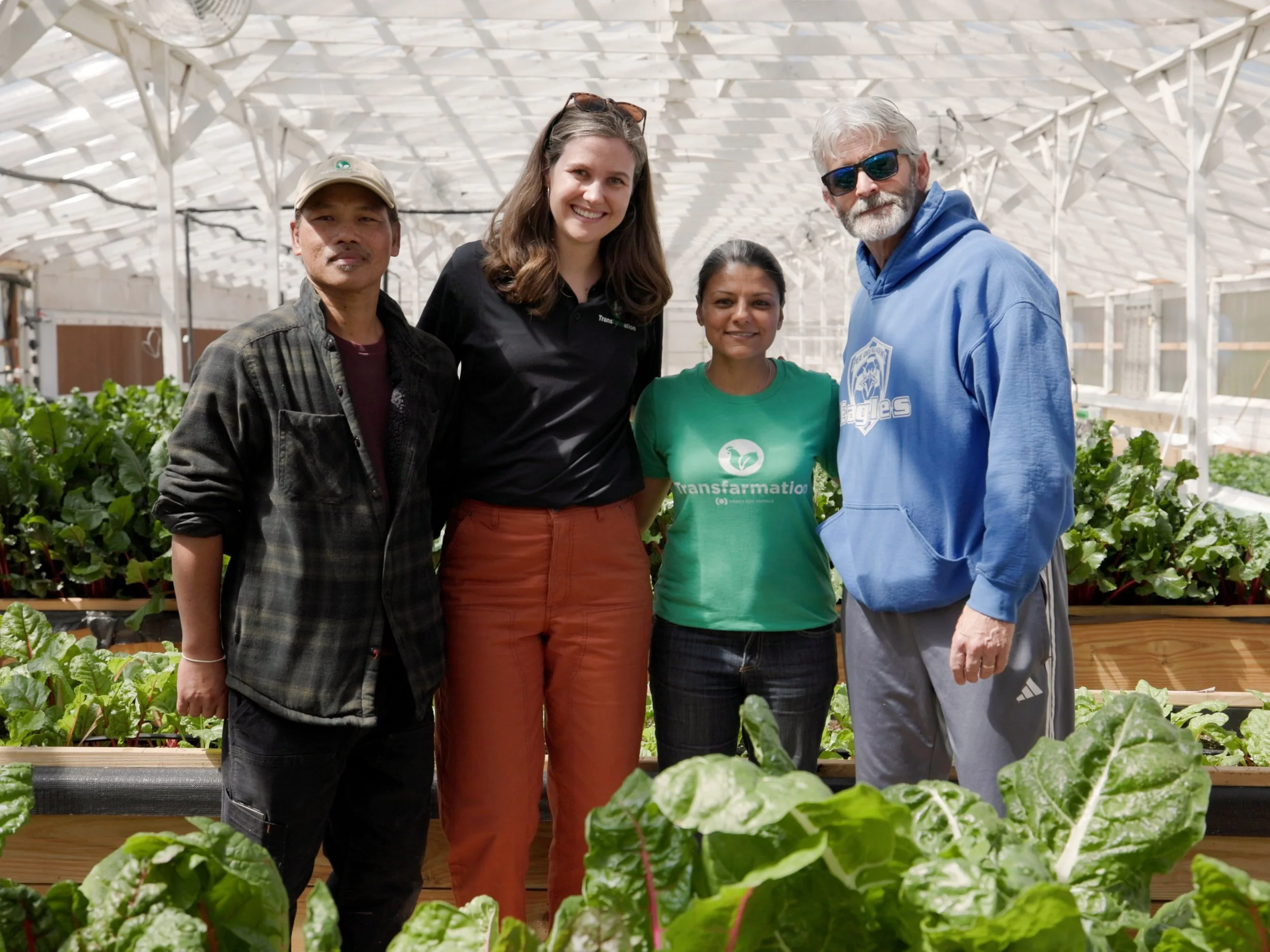 Individuals standing surrounded by plants in Transfarmation's demo hub