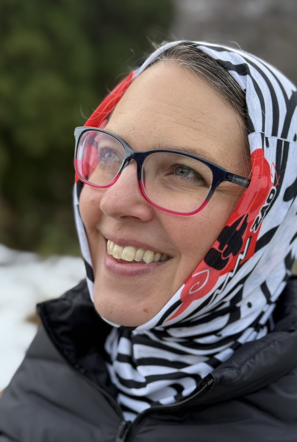 Woman looking away wearing a tube scarf over her head. Scarf has a red heart on her cheek and the words yuki and zao are visible on the size in red and black.