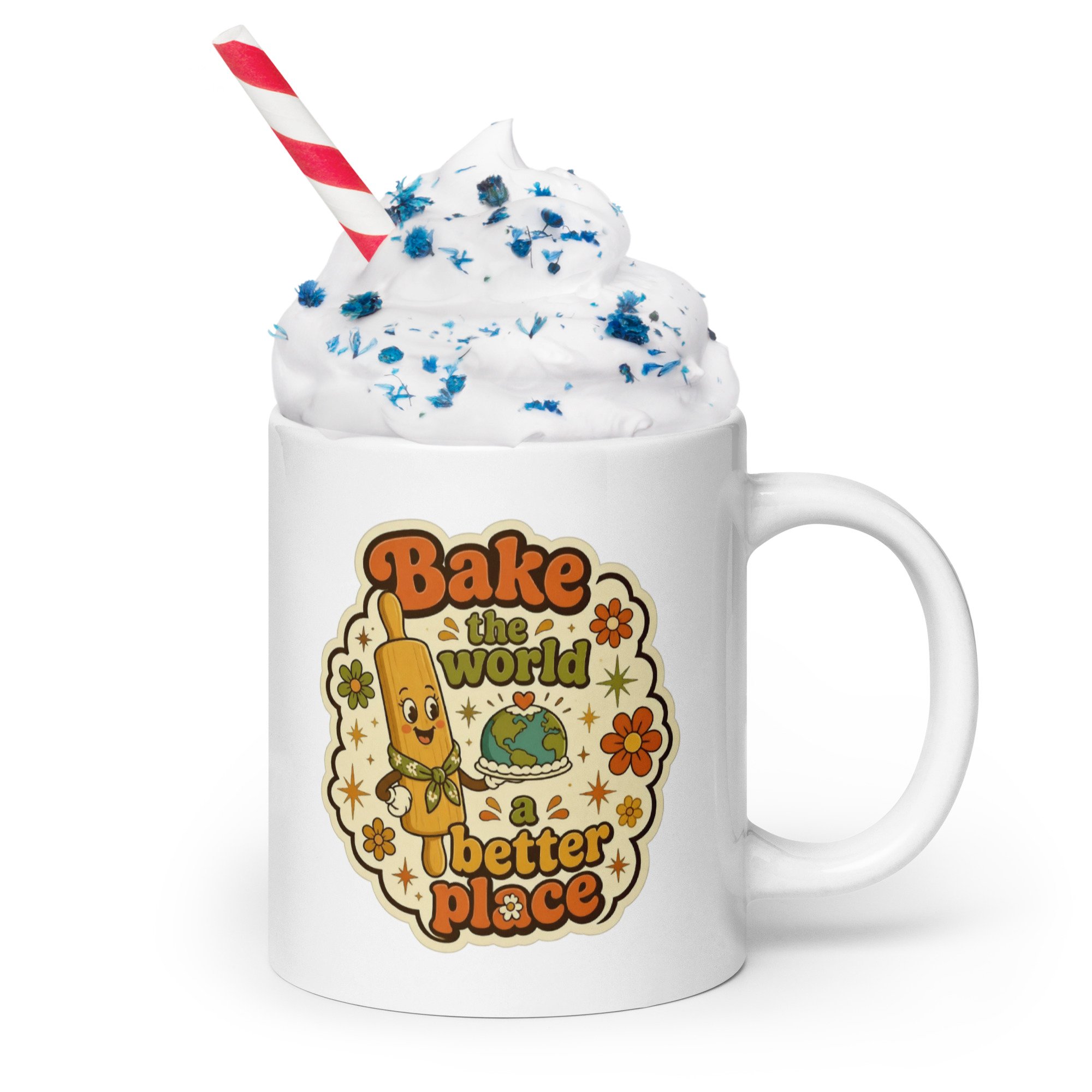 Retro baking mug with “Bake the world a better place” design filled with whipped cream and sprinkles, with a striped straw.