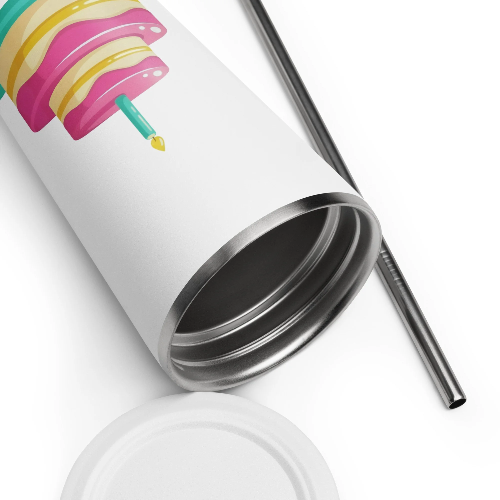 Close-up of the insulated tumbler showing the strawberry lemonade celebration cake design near the rim with straw beside it.