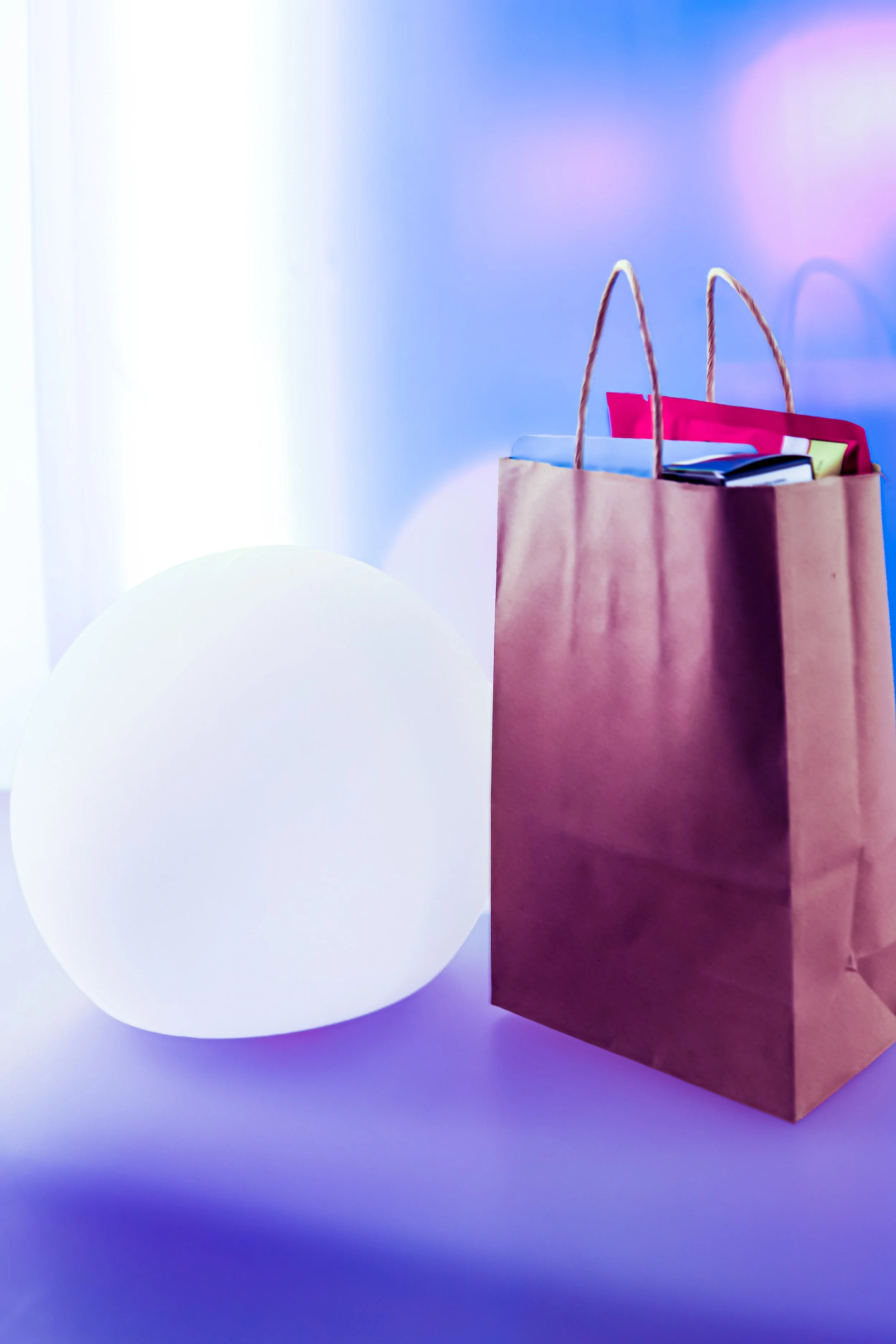 A plain white egg-shaped object next to a brown paper shopping bag with handles, set against a gradient background with soft blue and purple hues.