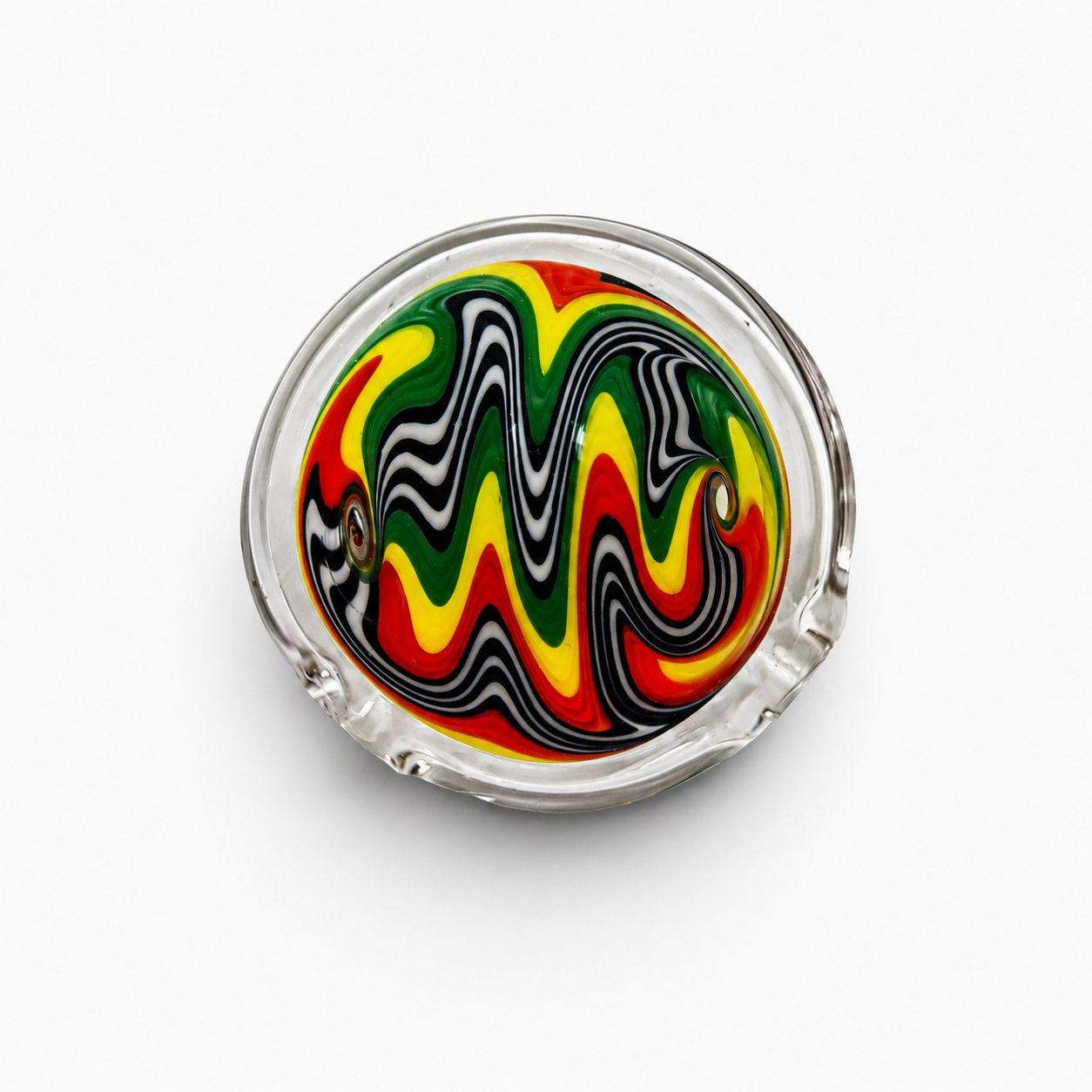 A top-down view of a glass ashtray with colorful, wavy swirl patterns in red, yellow, green, black, and white, on a white background.