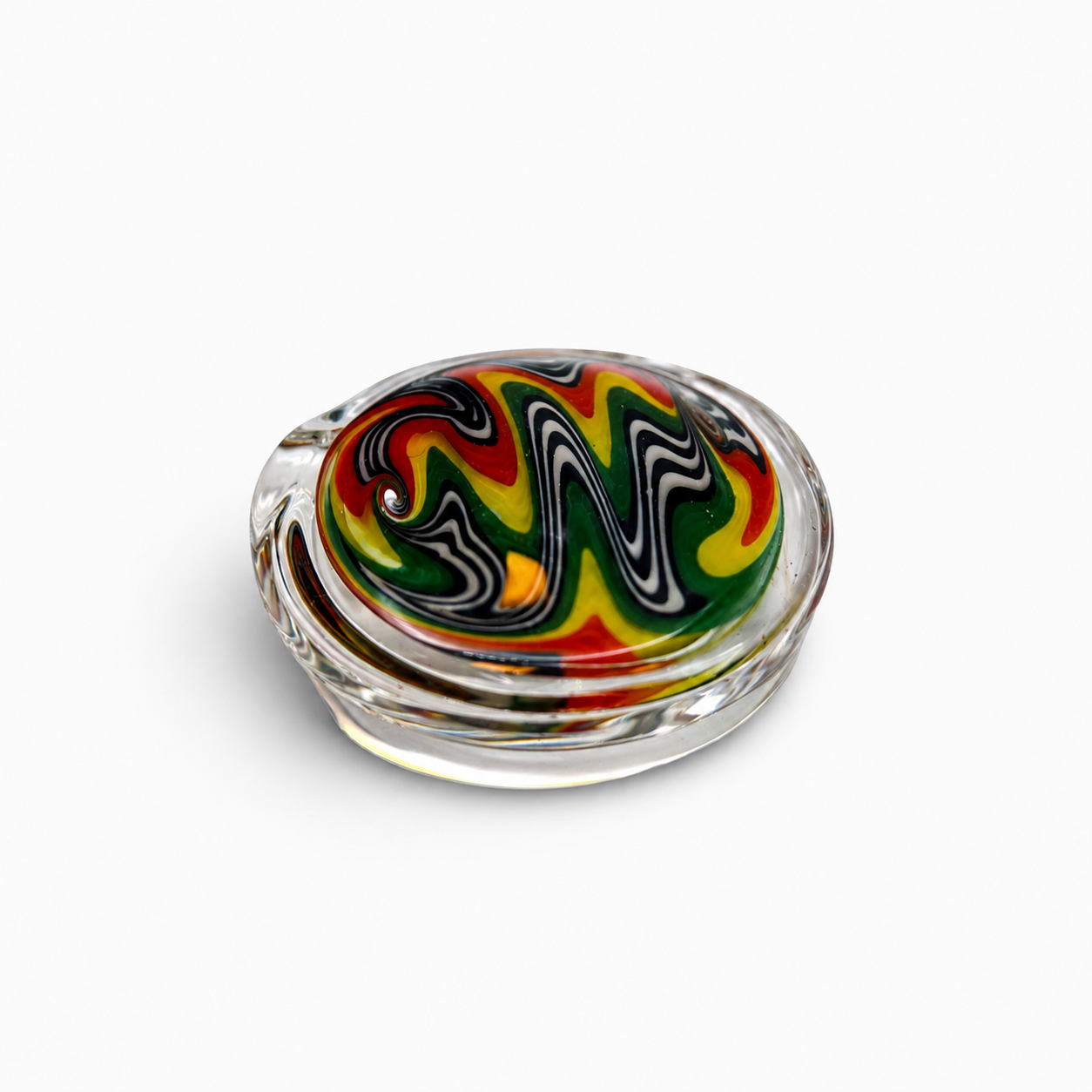 Colorful glass paperweight with swirled red, yellow, green, black, and white patterns on a white background.