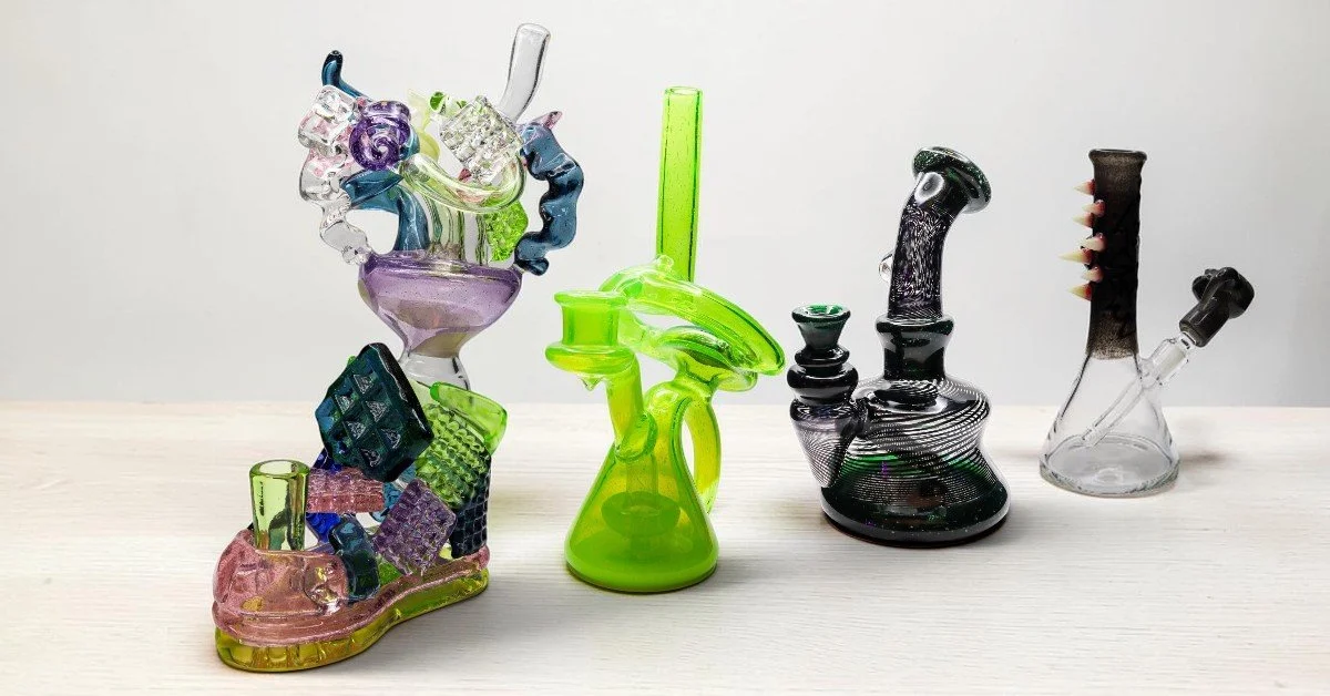 Four colorful glass bongs on a white surface.
