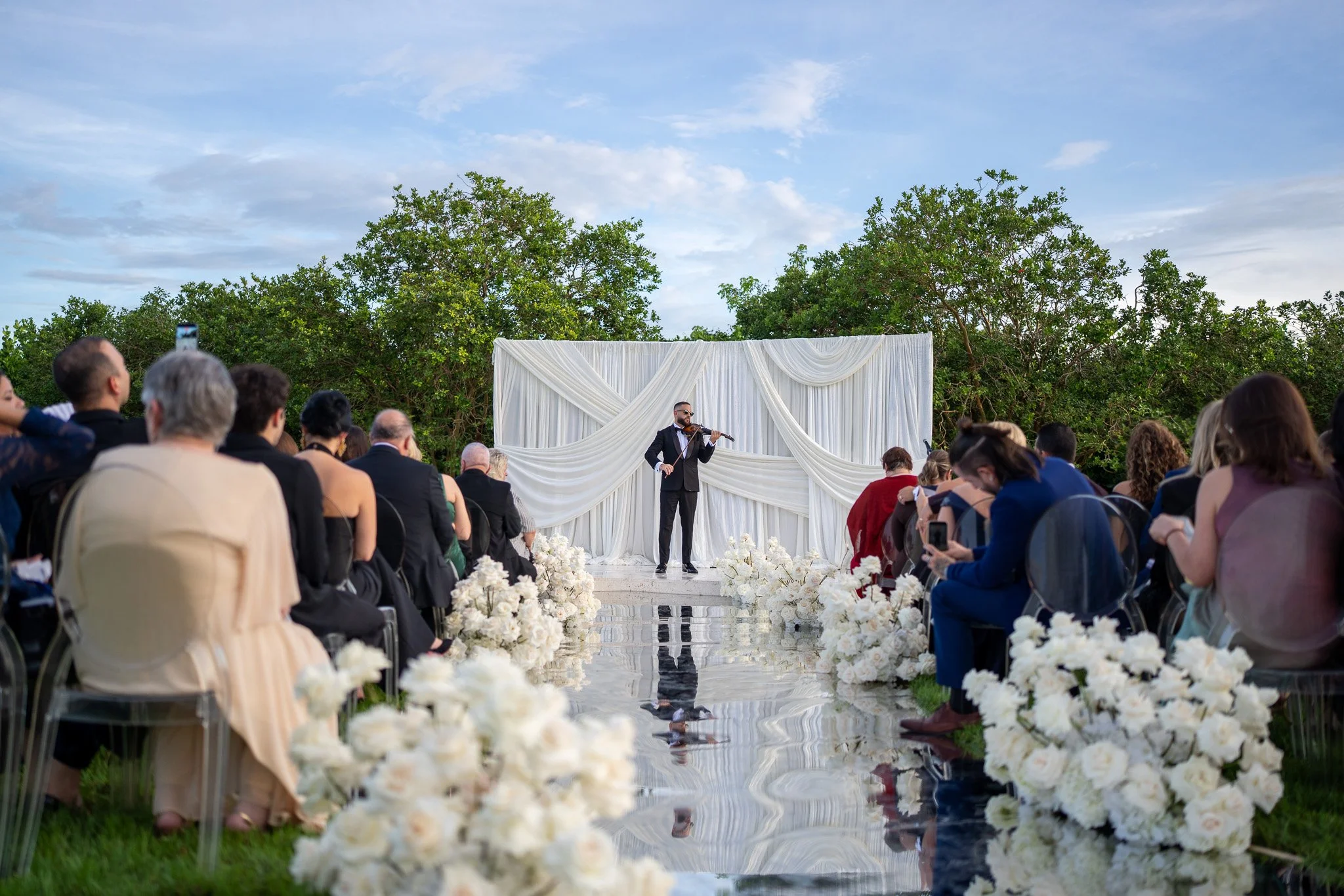 Live violinist performing during an outdoor wedding ceremony at The White Orchid in Miami